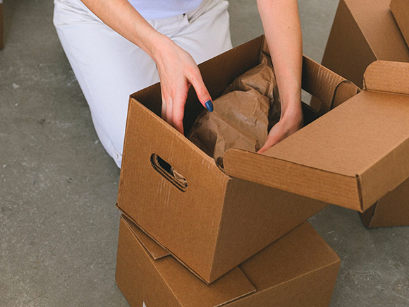 Woman packing things into cardboard