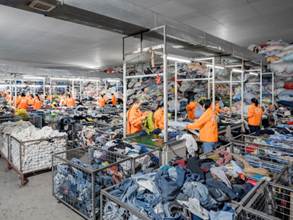 Workers sorting out the best second hand clothes in a warehouse