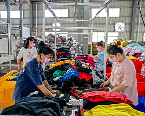 Indetexx worker inspecting individual garments against visible condition rules
