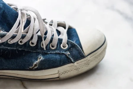 severely used shoe with a visible tear